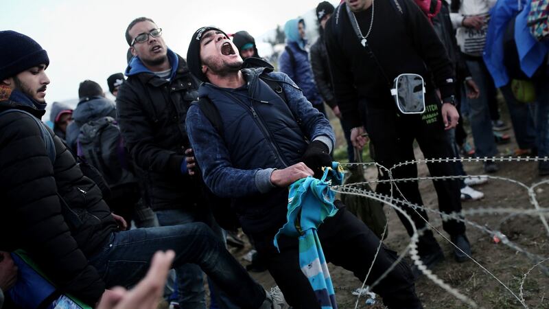 Migrants try to remove a fence at the Greek-Macedonian border, near the northern Greek village of Idomeni. Photogrpah: AFP/Getty Images