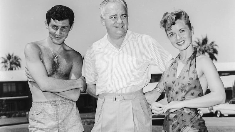A handout photo dated 1954 made available by the Las Vegas News Bureau  shows US actors and singer Eddie Fisher (L) and  Debbie Reynolds (R) with casino owner Wilbur Clark (C) at Clark’s Desert Inn in Las Vegas, Nevada, USA.