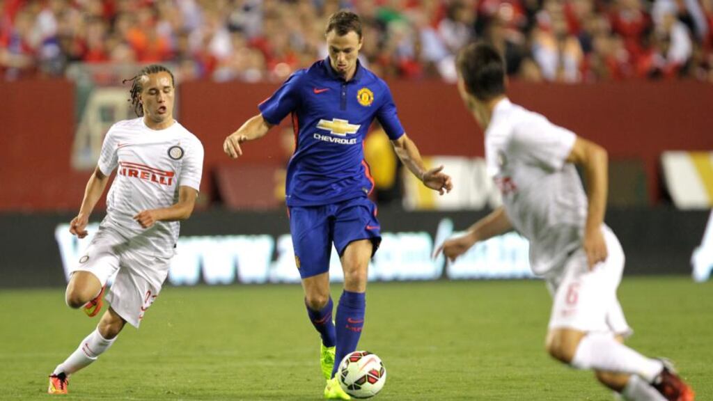 Manchester United’s Jonny Evans, center, moves the ball as Inter Milan’s Diego Laxalt, left, and Marco Andreolli defend during the second half of the 2014 Guinness International Champions Cup. Photograph: AP Photo/Luis M. Alvarez