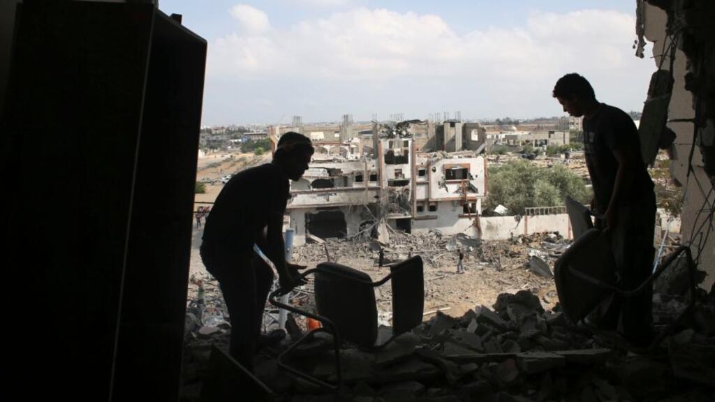 Palestinians salvage their belongings from their house, which witnesses said was badly damaged during the Israeli offensive, in the east of Rafah in the southern Gaza Strip, yesterday. Photograph: Reuters/Ibraheem Abu Mustafa