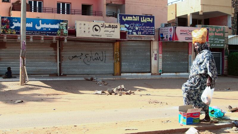A woman walks past shuttered shops in Sudan’s capital, Khartoum, on Thursday. Photograph: AFP via Getty Images