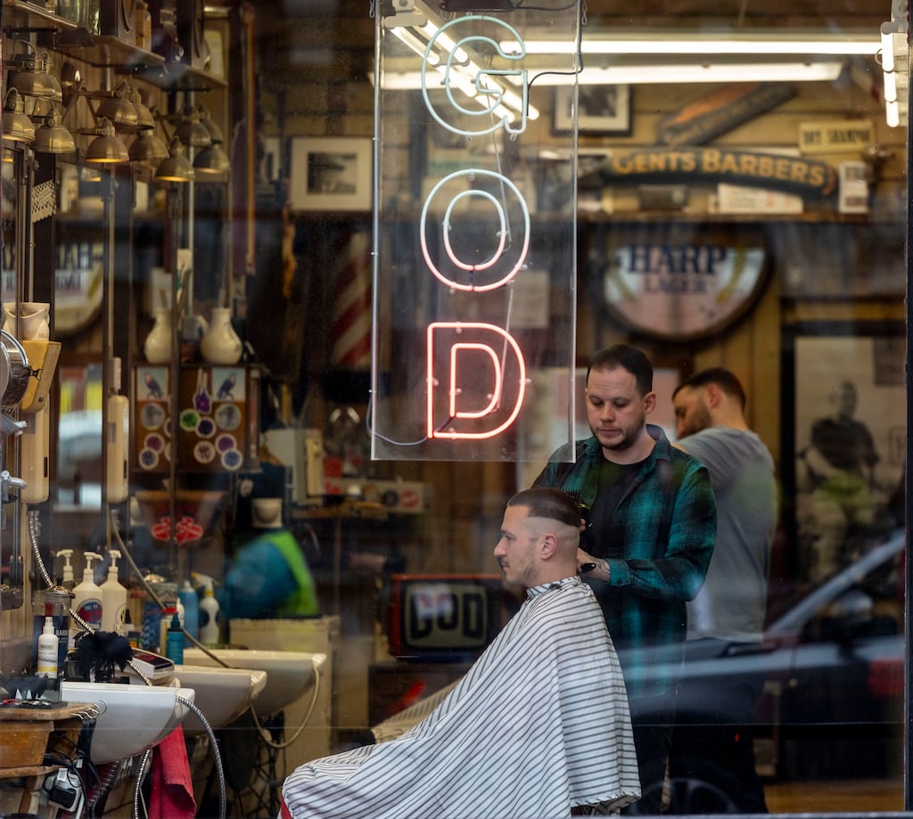 Barber shops are very male spaces. Yet while football is the lingua franca, an entry method for serious discussions or gentle joshing, it also seems to be a way of comforting clients. Photograph: Tom Honan