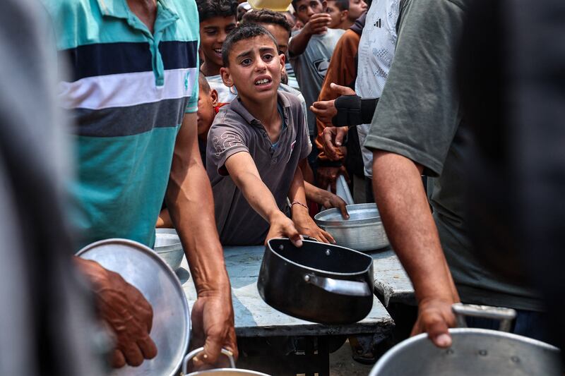 Palestinians gather to receive a hot meal at a food distribution point in the Nuseirat camp for refugees in the central Gaza Strip on Wednesday. Photograph: Eyad Baba/AFP via Getty Images