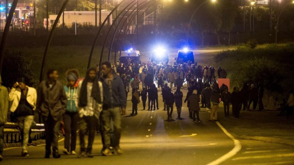 Gendarmes escort migrants away from the Eurotunnel terminal. France has bolstered its police presence in Calais. Photograph: Philippe Huguen/AFP/Getty Images