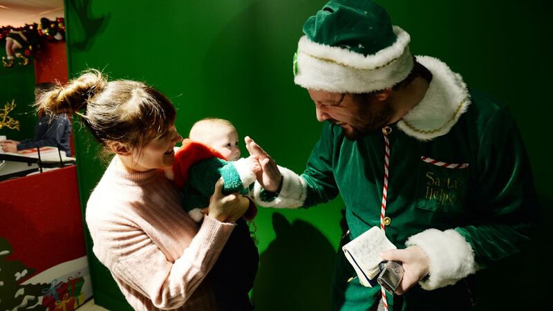 Elf Patrick Freyne with Sinead Ebbs and nine-month-old James from Tallaght at Arnotts. Photograph: Alan Betson