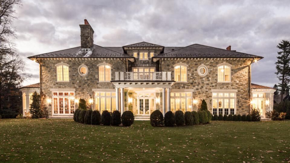 New stone estate house in Belle Haven, Greenwich, Connecticut: The exterior design includes an all-stone veneer with a slate roof and custom windows and doors, and an outside fireplace for spring and autumn. The house covers 7,000sq ft