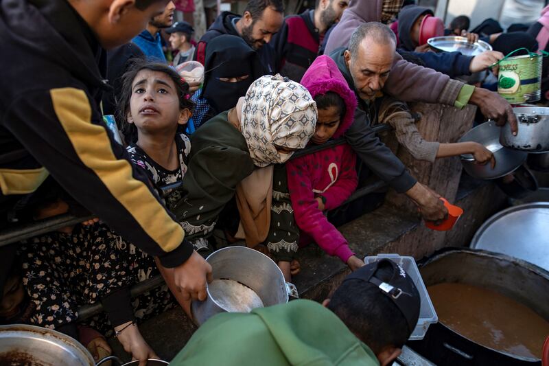 Internally displaced Palestinians in Rafah collect food before breaking fast during Ramadan. Photograph: Haitham Imad/EPA