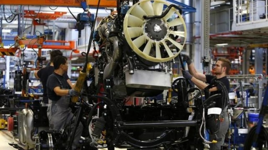 Men work at the assembly line in the truck production plant of truck and bus-maker MAN AG in Munich, Germany