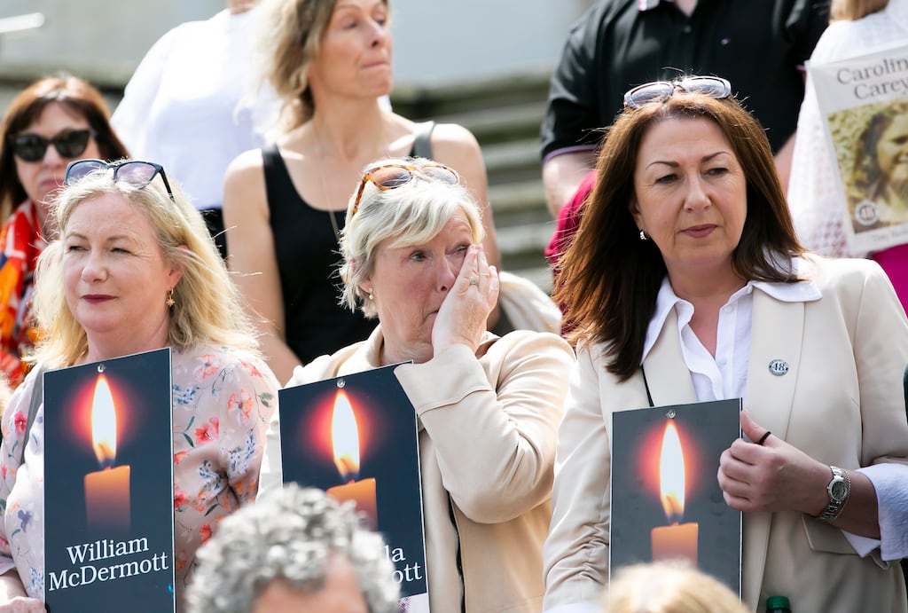 Stardust Verdicts: Louise McDermott, June McDermott and Selina McDermott hold photos of siblings William McDermott, Marcella McDermott and George McDermott who all died in the Stardust fire at the Garden of remembrance following the Coroners Court inquiry. Photograph: Gareth Chaney/ Collins Photos