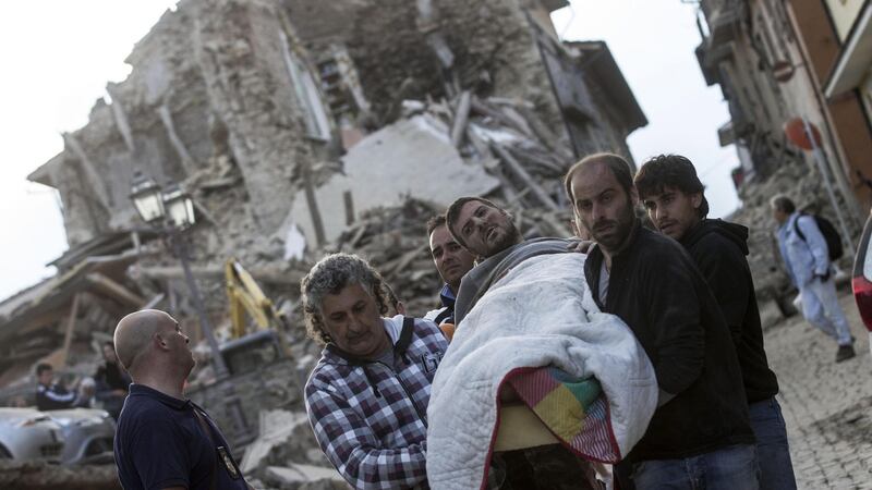 An injured man is carried after being rescued from the rubble of a collapsed building in Amatrice, central Italy following an earthquake. Photograph: Massimo Percossi/EPA