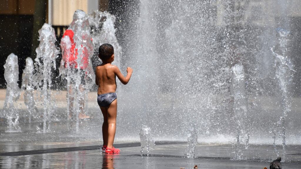 A boy gets refreshed at a water fountain in Montpellier in France. Photograph: Pascal Guyot/AFP