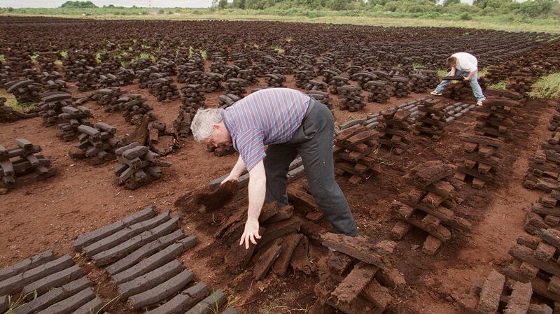 John Kehoe and James Connolly stack turf to dry on a bog outside Portarlington in October 2015. Photograph: Alan Betson ..