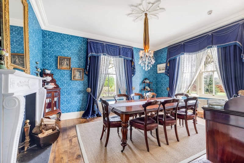 The diningroom has a candle chandelier and is blue to match the family collection of Royal Crown Derby chinaware
