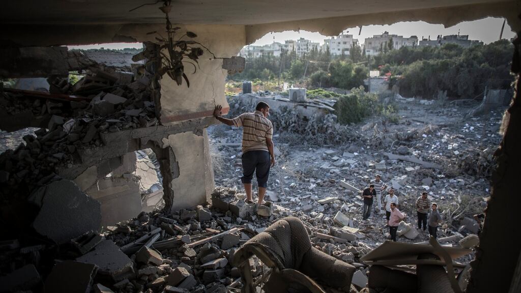 A Palestinian man stands in the remains of his living room shortly after his home was hit by an Israeli airstrike in Gaza City in August 2014. Photograph: Oliver Weiken/EPA