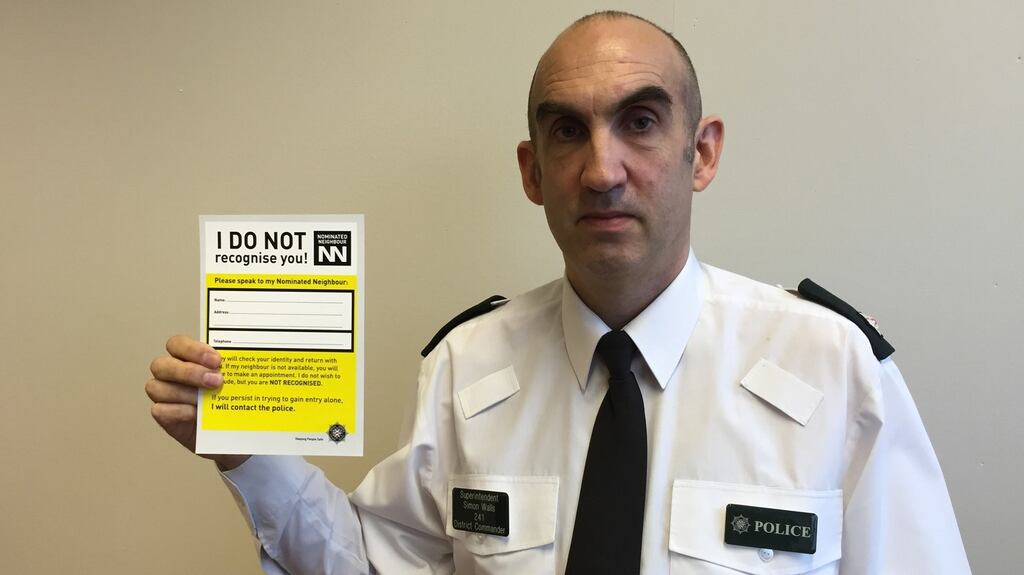 Supt Simon Walls holds up a notice relating to the nominated neighbour scheme at PSNI headquarters in Belfast. Photograph: David Young/PA Wire