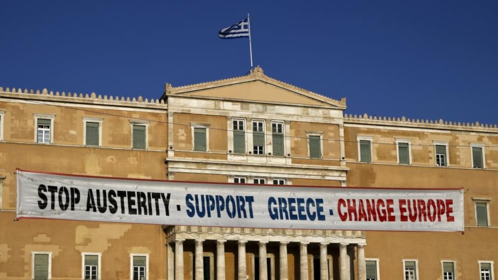 A banner hangs in front of the parliament during a pro-government rally calling on Greece’s European and International Monetary creditors to soften their stance in the cash-for-reforms talks. Depositors have been withdrawing cash, fearing that the the Greek government might be forced – at some stage – to put a levy on savings, as happened in Cyprus, or that Greek euro zone exit may lead to big losses. Photograph: Yannis Behrakis/Reuters.