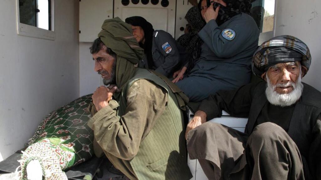 Relatives and police women sit in the back of an ambulance transporting the body of a senior female police officer for burial in Helmand province. Photograph: Abdul Malik/Reuters