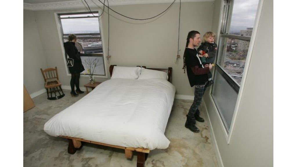 Seamus Nolan, the artist who conceived Hotel Ballymun, with his
son Etain (2) in one of the hotel rooms in Clarke Tower, Ballymun,
Dublin, and artist Lisa Marie Johnson