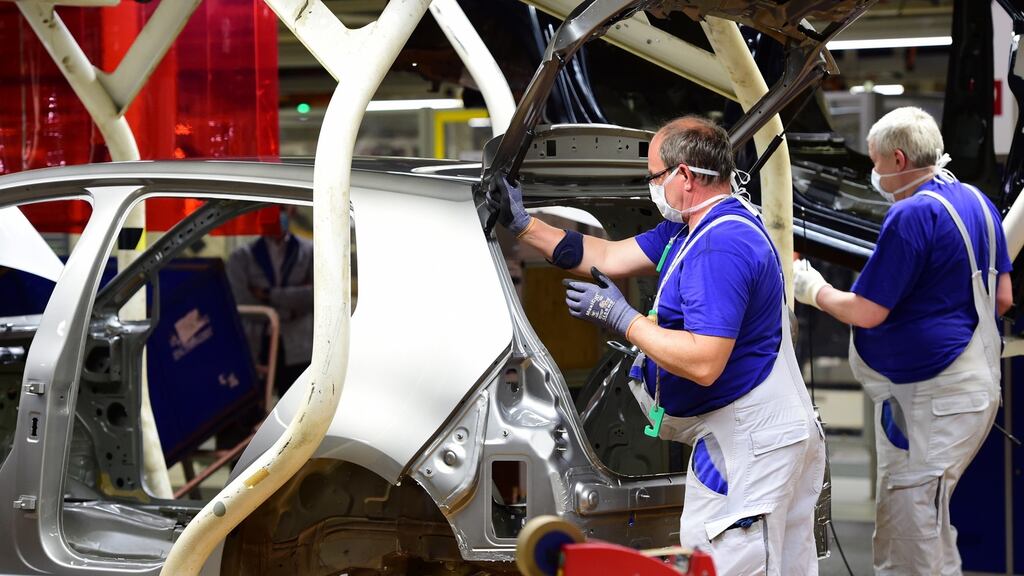 Workers wearing face masks on the car assembly line on the first day of the resumption of car production during the pandemic, at the Volkswagen factory in Wolfsburg, on Monday. Photograph: Alexander Koerner/EPA