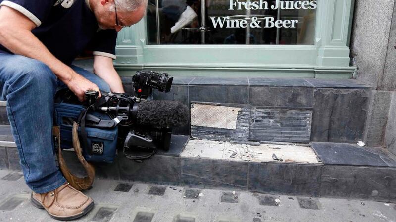 A camera man films broken slates outside a cafe in London. Local media reported the tiles had shattered from sunlight reflected by the Walkie Talkie tower. Photograph: Stefan Wermuth/Reuters