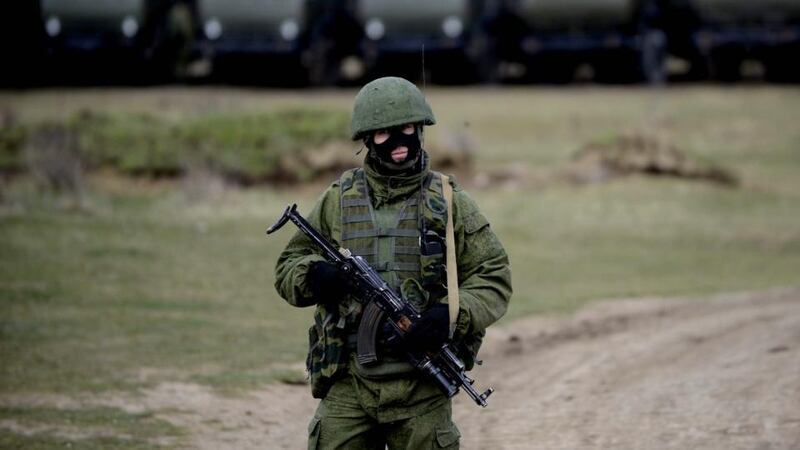 An armed man in military uniform is seen around the territory of a Ukrainian military unit, in the village of Perevalnoye, outside Simferopol. Photograph: Jakub Kaminski/EPA.