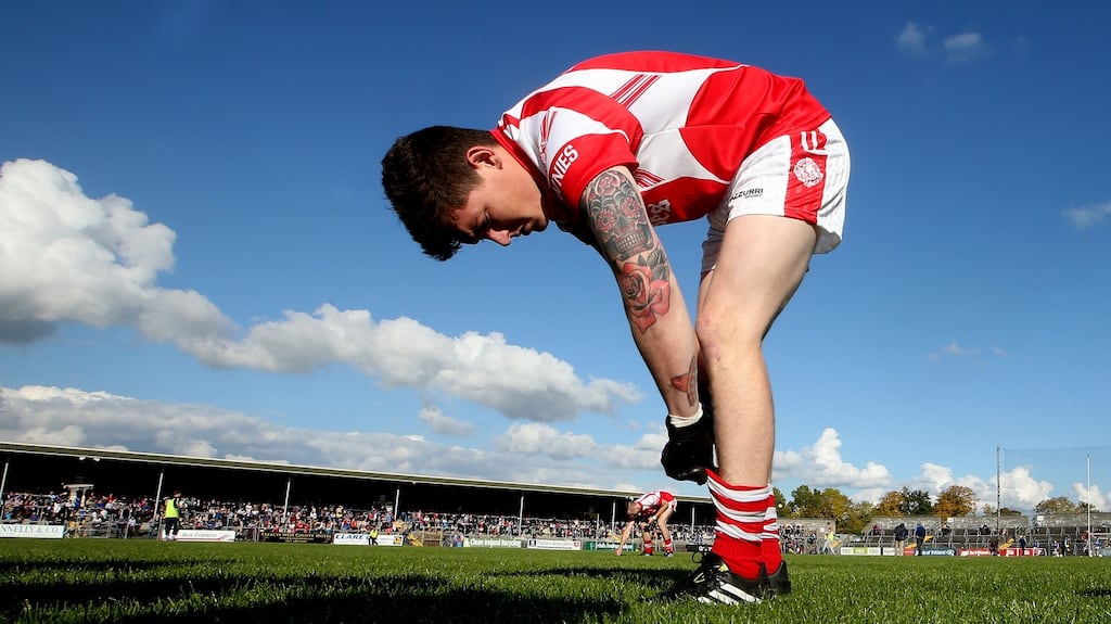 Éire Óg’s Aaron Fitzgerald adjusts his socks after the team photo. Photograph: James Crombie/Inpho