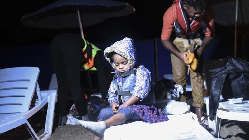 A child waits as migrants prepare to board a boat to reach the Greek Island of Kos from Turkish side Bodrum early on Thyursday. Photograph: Bulent Kilic/AFP/Getty Images