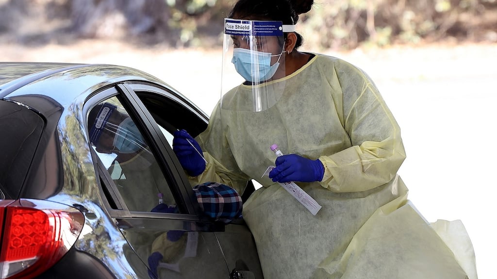 A healthcare worker carries out Covid-19 testing at a drive-through clinic in Perth, Australia. Perth is on alert after a hotel quarantine security guard and two of his housemates tested positive for Covid-19. Photograph: Paul Kane/Getty