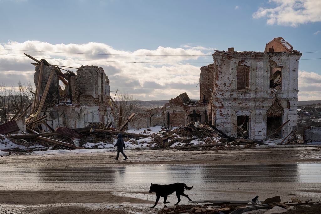 A woman walks by a building destroyed by a Russian strike in Kupiansk, Ukraine. Photograph: Vadim Ghirda/AP