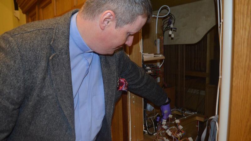 The Rector of Christ Church, Archdeacon Robert Miller, inspects the church’s damaged organ. Photograph courtesy Christ Church.