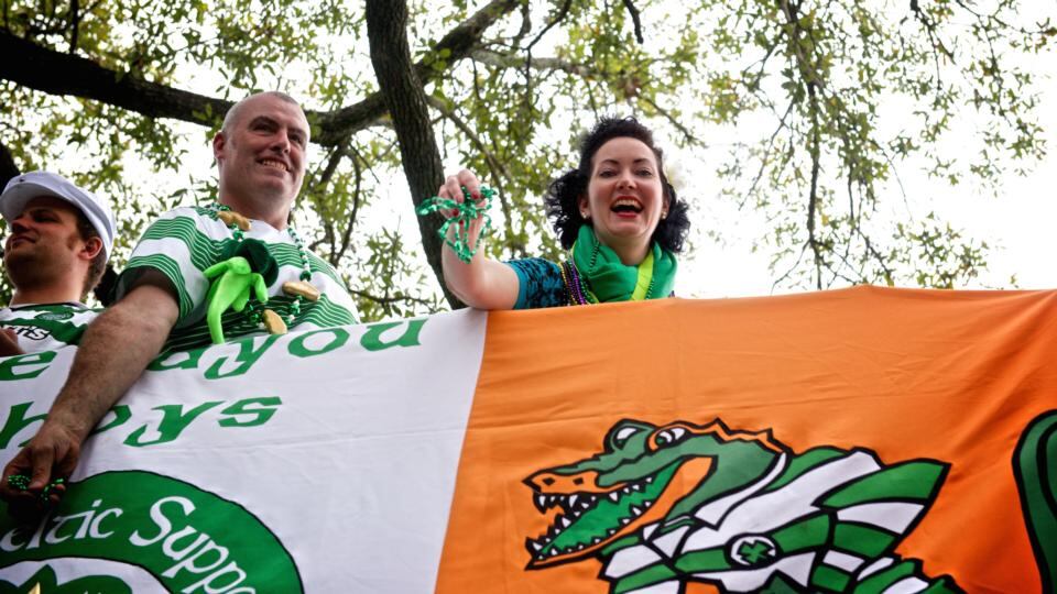 Stephen Patterson, owner of Finn McCool’s Irish Pub, and singer/songwriter Tara O’Grady throw beads along the parade route during St Patrick’s Day in New Orleans