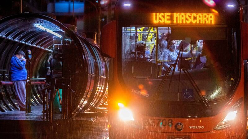 Commuters wearing face masks travel on a public bus with an electronic sign reading “Wear a face mask”, in Curitiba, Brazil on Friday. Photograph: Getty Images