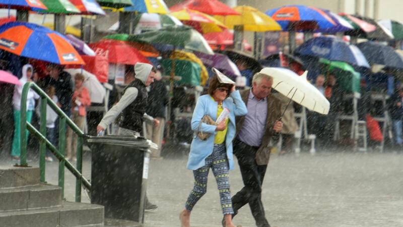 Punters at the Galway Races attempt to take shelter from the rain. Photograph: Cyril Byrne