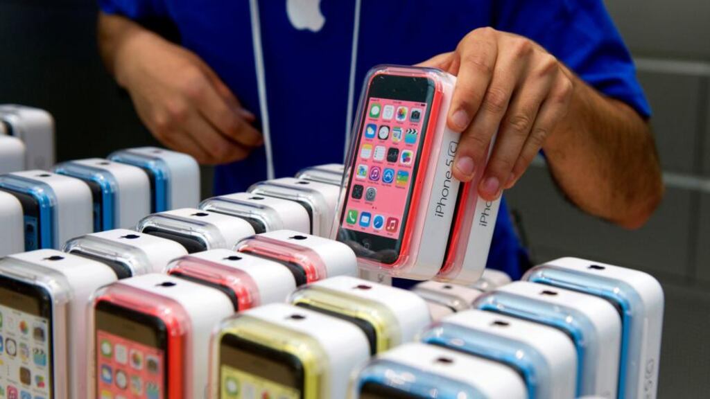An employee arranges Apple iPhone 5c and 5s devices. The iPhone 6 was expected to be launched in September. Photographer: David Paul Morris/Bloomberg