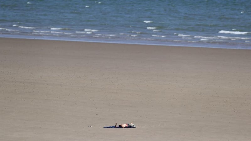 A man lies on Portmarnock beach, Co Dublin, as the warm weather continues. Photograph: Brian Lawless/PA Wire