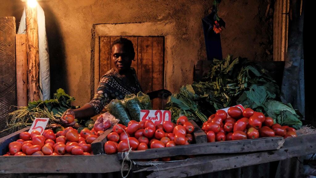A woman makes a selection of the most expensive tomatoes for a customer just before the 7pm curfew in Kibera, Nairobi on Tuesday. Since Kenya confirmed its first case of Covid-19 on March 13th, authorities have adopted various measures to curb the spread of the virus while stopping short of imposing a full lockdown. Photograph: Kabir Dhanji/AFP via Getty