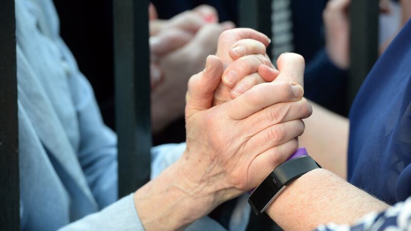 A member of the public offers support to a former Magdalene Laundry resident at the ‘Dublin Welcomes Home the Magdalenes’ event at the Mansion House. Photograph: Cyril Byrne/The Irish Times.