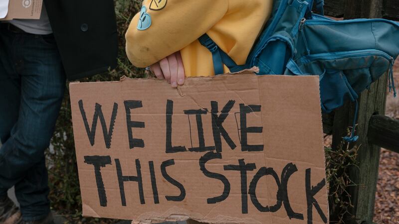A protester holds a sign outside Robinhood’s headquarters in California on Thursday after the stock-trading app said it would limit trades in GameStop. Photograph: The New York Times