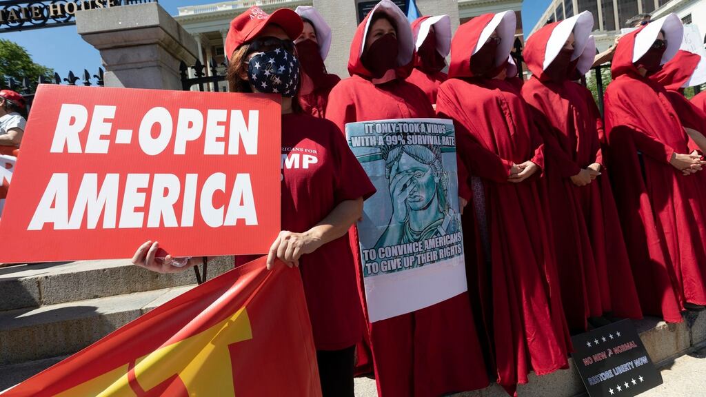 Women dressed like characters from The Handmaid’s Tale demonstrate against all government restrictions related to concern about the spread of Covid-19 outside the Statehouse in Boston. Photograph: Michael Dwyer/AP Photo