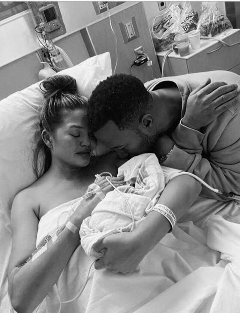 Chrissy Teigen,  husband John Legend cradle their baby. Photograph: Chrissy Teigen/Instagram