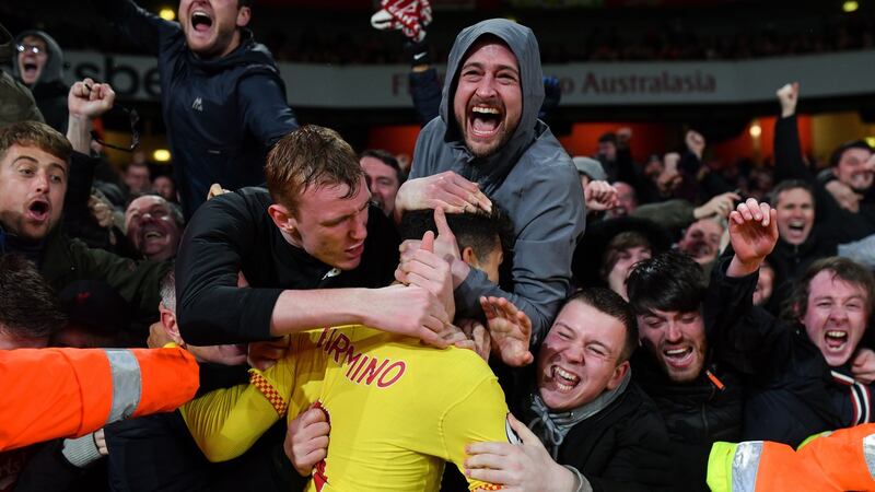 Roberto Firmino mobbed by Liverpool fans after sealing victory at the Emirates Stadium. Photograph: Justin Setterfield/Getty Images