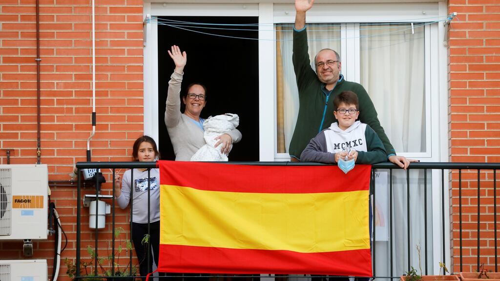 Nuria Bravo holds to her newborn son Jesus next to her husband Francisco Pimentel, and their children Cristina and Daniel as they greet to the neighbours from the balcony of their house after she gave birth during a lockdown amid the coronavirus disease, in Ronda. Photograph: Jon Nazca/Reuters