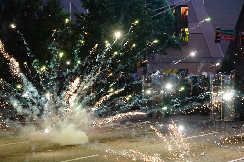 A firework explodes in front of a police line in Atlanta. Photograph: Elijah Nouvelage/Getty
