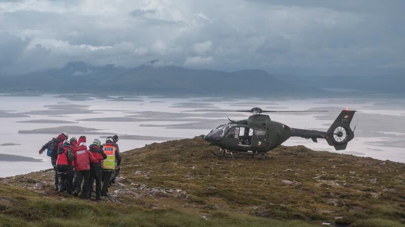 Mountain Rescue carries a casualty towards a helicopter to be airlifted off the mountain. Photograph: Michael McLaughlin
