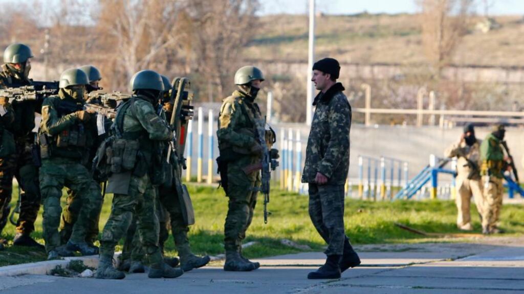 A Ukrainian serviceman (right, front) talks to armed men, believed to be Russian servicemen, at a military airbase in the Crimean town of Belbek near Sevastopol. Photograph: Reuters