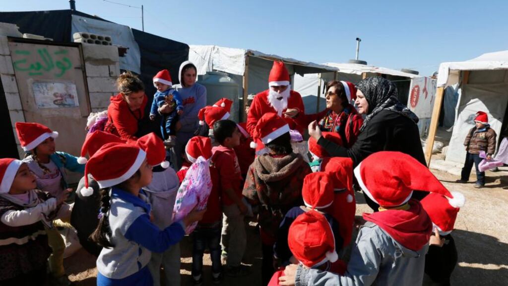A man dressed as Santa Claus from NGO SAWA delivers toys to Syrian refugee children at a refugee camp in the Bekaa valley in Lebanon. There are more than 1.1 million Syrians seeking refuge in Lebanon. Photograph: Jamal Saidi/Reuters