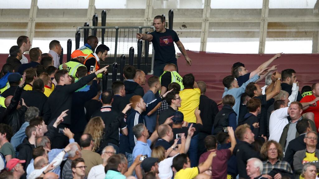 A West Ham fan, top, gestures towards Watford fans during the Premier League football match between at London Stadium, in east London. Photograph: Justin Tallis/AFP/Getty Images