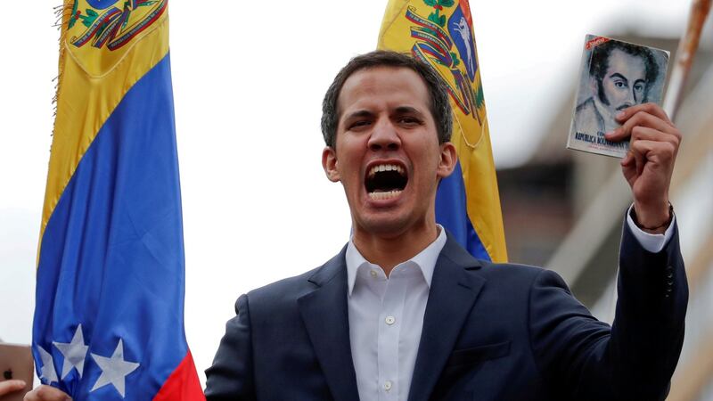 Juan Guaidó, leader of the Venezuelan opposition holds a copy of Venezuelan constitution during a rally against Nicolás Maduro’s government in Caracas. Photograph: Carlos Garcia Rawlins/Reuters