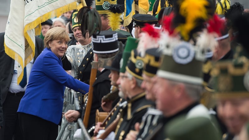 German chancellor Angela Merkel greets people dressed in historic coal miner uniforms as she arrives to attend festivities to celebrate the day of German unity in Dresden. Photograph: Sebastian Kahnert/AFP/Getty Images