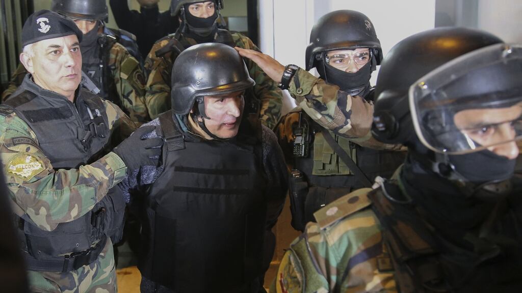 Argentinian former public works secretary Jose Lopez is taken into custody after being arrested in General Rodriguez, province of Buenos Aires: he was trying to hide $9 million in the garden of a nunnery. Photograph: Juan Vargas/AFP/Getty Images